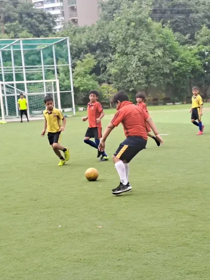 A player prepares to take a shot during the boys' football tournament. Our coaching focuses on developing fundamental skills like shooting, passing, and dribbling.