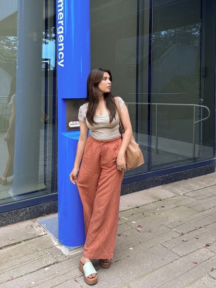 A casual, full-length outfit shot against a bright blue wall.