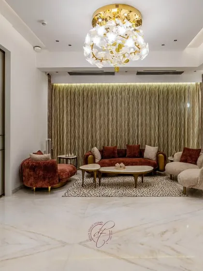 This living room is a study in warm, emotional elegance. We used rich, rust-colored velvet for the sofa and armchair, creating a cozy and inviting atmosphere. The statement chandelier and polished marble floors add a touch of timeless luxury.