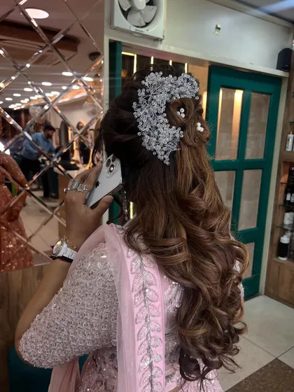 A candid moment of a client on the phone, showing off the back of her beautiful updo, complete with a large, sparkling hairpiece.