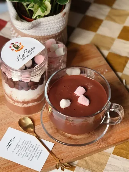 My Hot Cocoa Drink Mix, beautifully presented with a finished cup of thick, rich hot chocolate. The jar is layered with cocoa powder, sugar, chocolate chips, and marshmallows, making it a perfect gift.