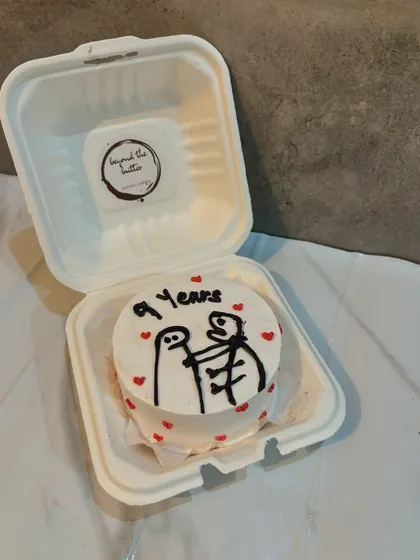A cute and quirky bento cake celebrating a 9-year anniversary with a funny stick figure drawing. It's a great way to add a personal and humorous touch.