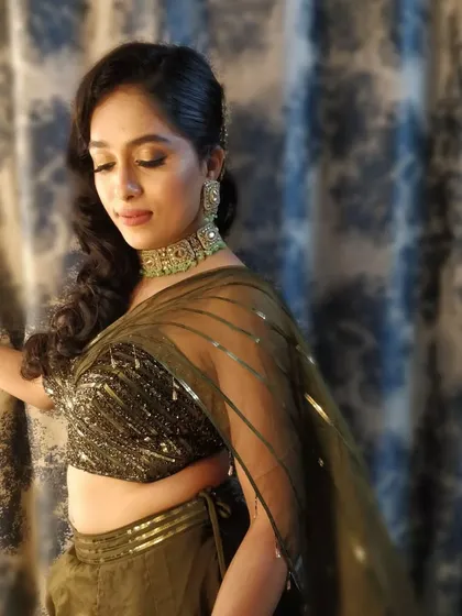 A candid moment from the engagement party. The bride's makeup is flawless, with a focus on radiant skin and defined eyes that sparkle in the evening light.