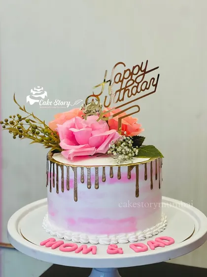 A lovely drip cake for Mom and Dad's combined birthday celebration. The pink marble effect is complemented by a gold drip and fresh flowers.