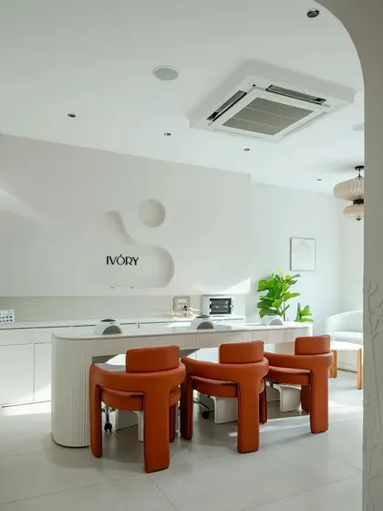 The main nail bar is set against a feature wall with a custom-carved organic shape, reinforcing the salon's brand identity.