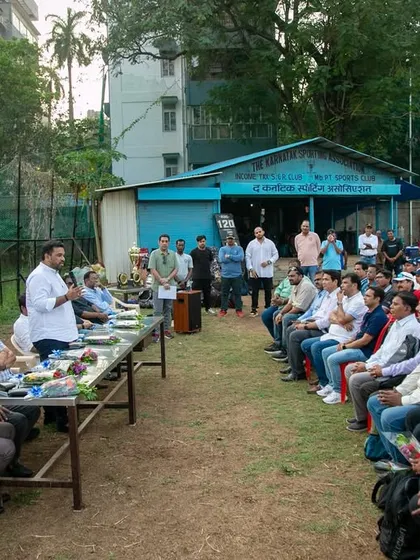 An overview of the audience, including players, parents, and coaches, listening intently during the prize distribution ceremony of the U-16 Payyade Trophy at Karnatak Sporting Association.