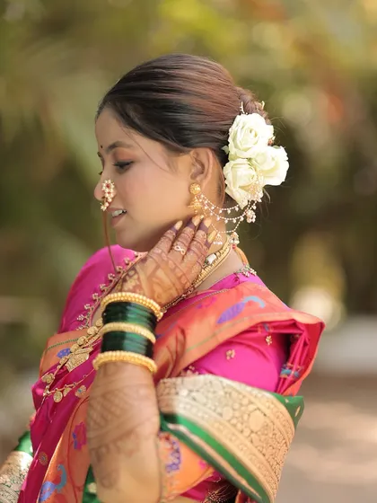 A side view highlighting the bride's floral bun and the details of her saree.