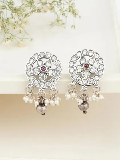 I have a special love for silver, and these earrings showcase its understated beauty. Crafted from genuine 92.5 silver, these studs feature a floral design with a central stone and delicate pearl drops. They are versatile enough for daily wear yet elegant enough for special occasions.