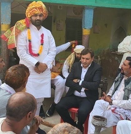 Listening to the concerns of elders at a village meeting. It is an honor to be welcomed with a traditional turban, a symbol of respect and responsibility.