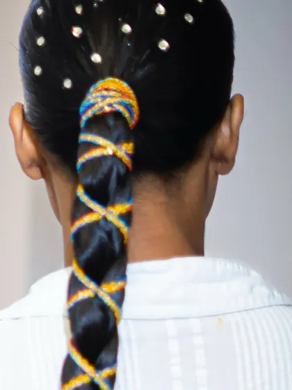 A detailed view of a creative braid, showcasing the precision of the weaving and the colorful threadwork.