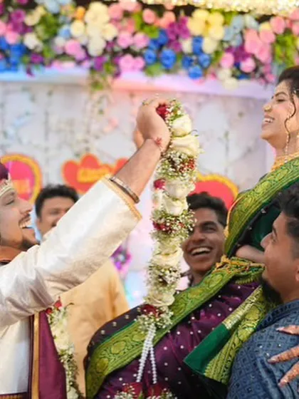 A fun and joyous moment from the varmala ceremony. The bride's makeup remains perfect even during playful moments.