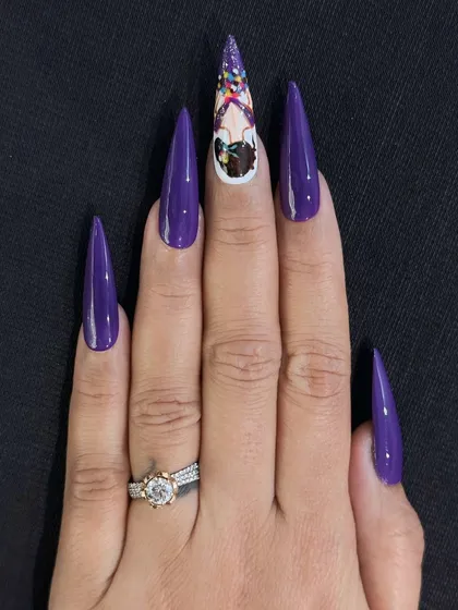This is an example of my custom hand-painted character art on long stiletto nail extensions. I used a vibrant purple base and created a detailed, unique character on the accent nail to showcase my intricate design capabilities.