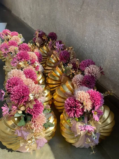 A collection of festive gift pots, each adorned with a large pink chrysanthemum. These are perfect as return favors or small individual gifts for a large celebration, showcasing our ability to handle bulk orders with style.