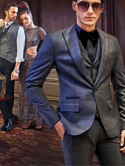 This image for SPAADAA focuses on modern formal attire. The model in the foreground is styled in a sleek grey tuxedo with a black bow tie, projecting a contemporary and sharp aesthetic for evening wear.