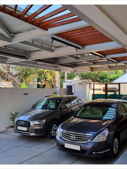 A view of the cantilevered steel and wood canopy for the car park of the residence. This structure is both functional and a key part of the building's modern aesthetic.