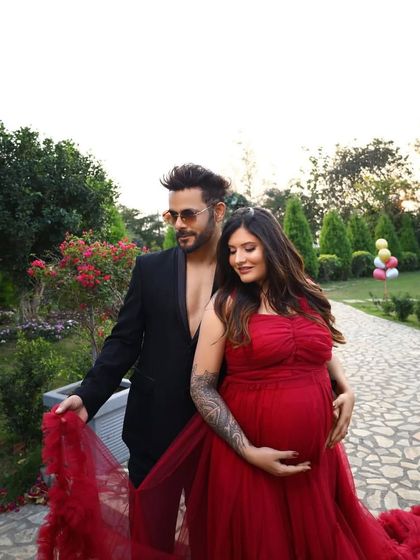 Maternity style with an edge. This mom-to-be shows off her beautiful tattoo in a stunning red off-shoulder gown. My collection is for every kind of mother, celebrating your unique personality.
