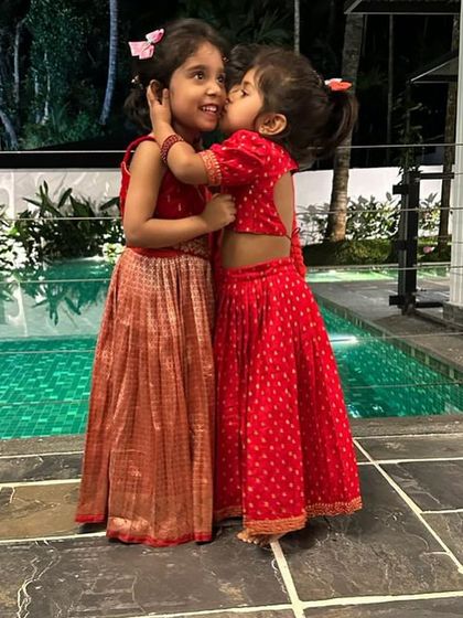 Sweet sibling moments. Little Kaanana and her sister in their custom red lehenga sets, perfect for a family wedding or festive celebration.