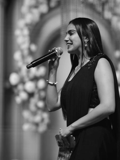 A black and white shot capturing a moment on stage. As an event host, I connect with the audience through my words and presence, ensuring the energy in the room is always high and the focus remains on the celebration.