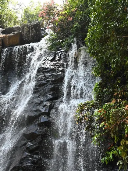 A close-up shot of a waterfall in the Agumbe region, showing the texture of the water and rocks.