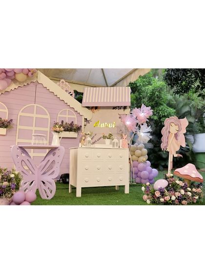 A wide shot of the purple fairy house setup, showing the main decor pieces like the butterfly table and the large fairy cutout, creating a cohesive magical scene.
