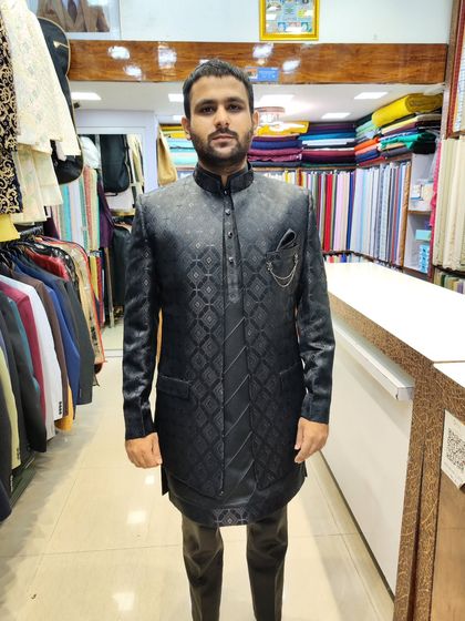 A full-length view of a client in the black geometric open jacket set, demonstrating a modern and sophisticated ethnic look.