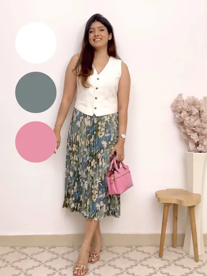 Here's a lovely color combination of grey, pink, and white. The pink bag adds a beautiful pop of color to the printed skirt and white waistcoat.