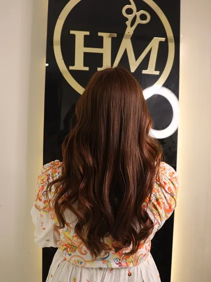 A beautiful, uniform warm brown color from roots to ends. This global hair color application gives a rich and consistent look, styled with soft waves to catch the light.