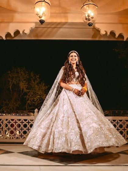 The bride twirls in her gorgeous lehenga under the arches of the palace hotel, a moment of pure elegance.