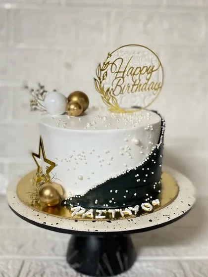 Our modern black and white cake on a stand, ready to be the centerpiece of a stylish party.