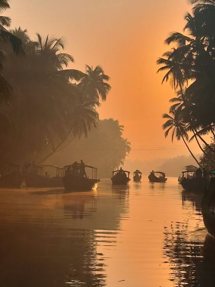 A fleet of boats on the misty river during sunrise in Honnavar, a truly magical sight.