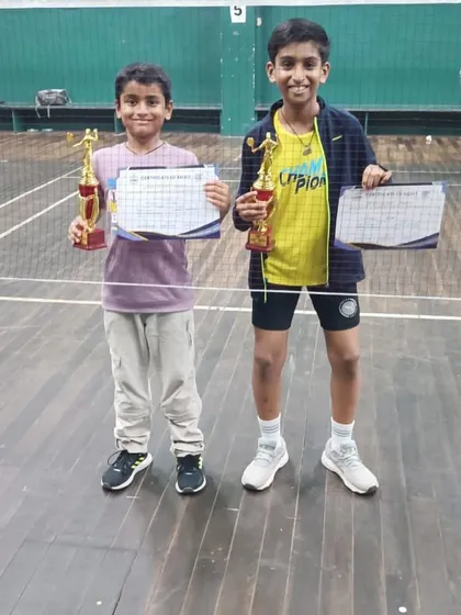 Young champions Ajinkya Desai and Kaavya Parmar showing off their trophies after winning their respective district-level tournaments.