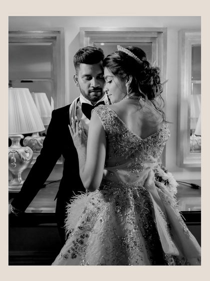 A timeless black and white portrait that emphasizes the emotion and connection between the couple. The intricate details of the bride's gown and the classic tuxedo create a look of pure, sophisticated elegance.