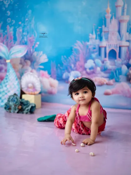A little mermaid explores the treasures of her underwater kingdom. The vibrant colors and whimsical props create a magical scene straight out of a storybook.