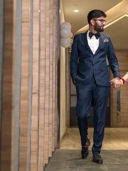 A wedding day is also a journey. This candid shot captures the couple walking hand in hand, sharing a private moment away from the crowd. The leading lines of the corridor create a dynamic composition for this reception photograph.