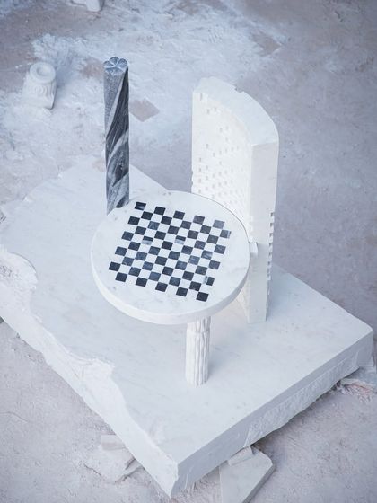 An overhead view of the Dori Patti chair on a raw block of marble. This perspective shows the piece as a functional sculpture, a piece of art born from the earth.