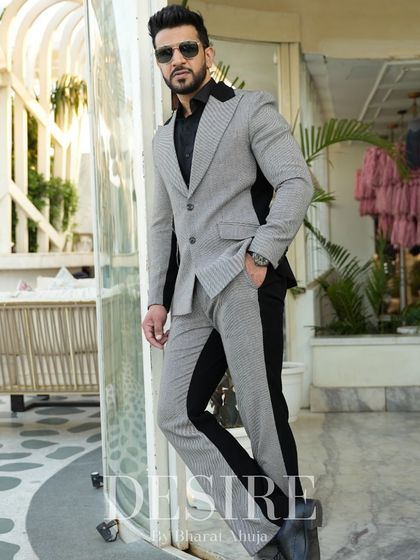Leaning with confidence, this image showcases the sleek silhouette of the grey and black color-blocked suit. It’s a look that is both modern and timeless.