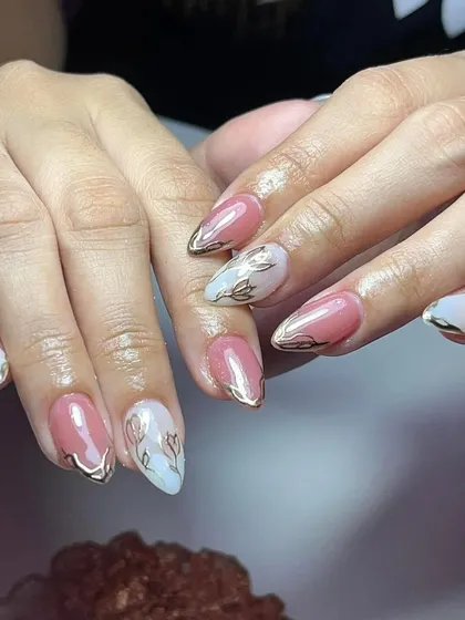 A beautiful set combining pink and white nails with delicate gold floral line art. The gold details add a touch of luxury.