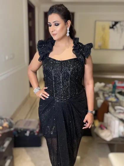 This full-length shot shows how a dramatic eye can balance a show-stopping black gown. It's a look that exudes confidence and style.