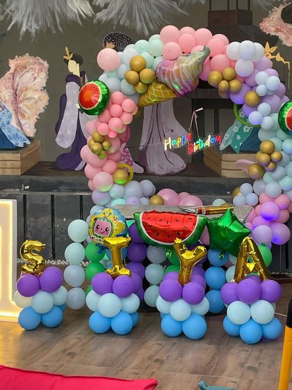 The Cocomelon and watermelon themed setup in normal light. You can see the details like the watermelon foil balloons and the custom foil letters for the name 'SIYA'.