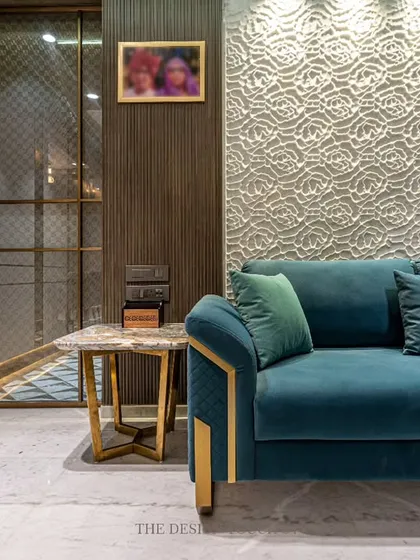 A close-up of the teal velvet sofa set against a textured white accent wall and a fluted glass partition. This highlights our focus on combining different materials and textures to create a visually rich environment.