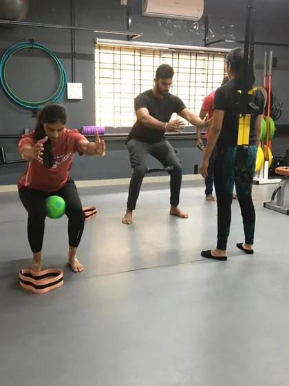 A trainer assists a student with a balance and coordination drill. This one-on-one attention is key to mastering complex movements.
