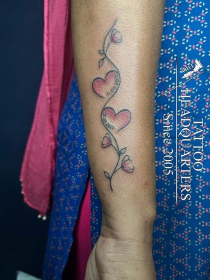 A vine with flowers and two hearts containing dates, a beautiful way to commemorate special family moments.