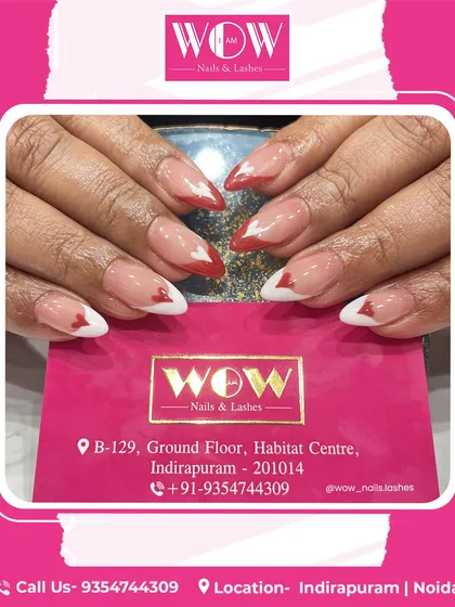 These heart-tipped extensions are a playful and romantic choice. The design features a neutral base with alternating red and white heart-shaped French tips on almond-shaped nails.