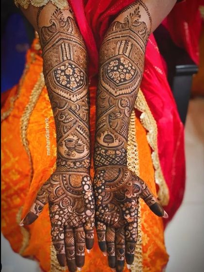 This design is packed with detail, featuring traditional Indian motifs like paisleys and diyas (lamps) within a structured, symmetrical layout.