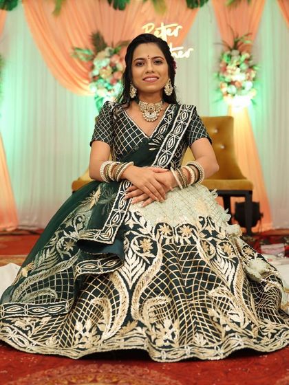 The full view of this dark green and off-white lehenga shows the stunning contrast and heavy gold embroidery on the skirt. It’s a regal choice for a wedding guest.