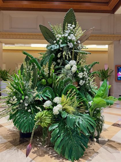 Another view of the lush green lobby installation, showing the variety of leaf shapes and textures used to create a rich, jungle-like feel.