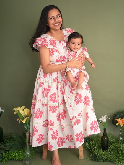 A mother and her baby in matching floral dresses for their Mother's Day portrait. This sweet photo celebrates the beautiful bond between a mom and her little one.