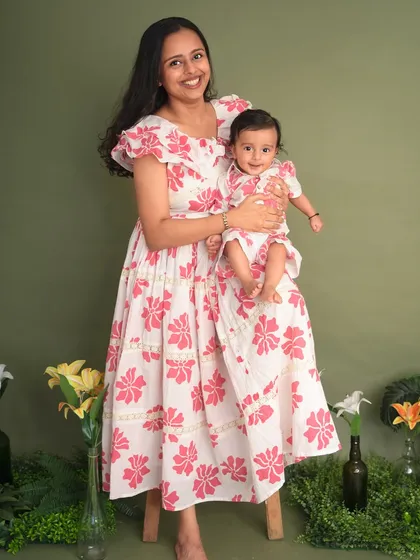 A mother and her baby, twinning in beautiful floral dresses. This portrait captures the gentle and loving bond between them.