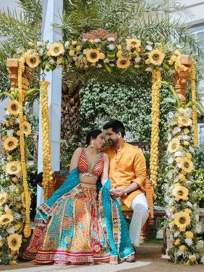 A quiet, tender moment during a vibrant Haldi ceremony in Jaipur. The couple shares a look of love on a swing adorned with sunflowers, showing my ability to find serene moments amidst the joyous celebrations.
