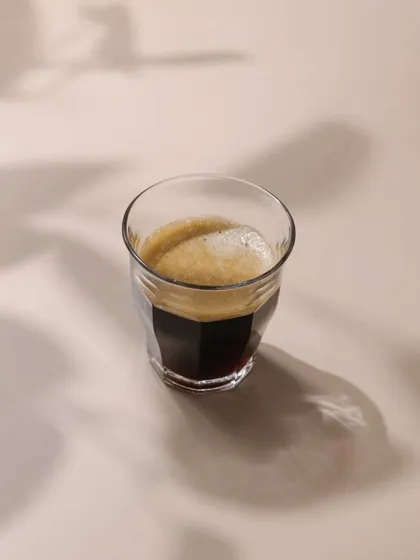 A minimalist shot of an espresso, created for a Bangalore-based coffee brand. This image is clean and modern, focusing on the beautiful crema and shadows.